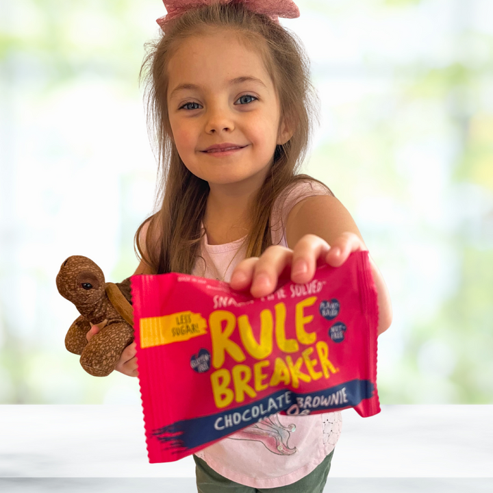 Girl holding a delicious Rule Breaker Snack allergen-free Brownie Junior