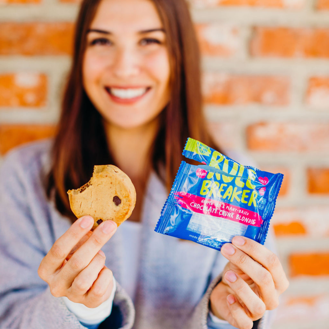 Woman holding Rule Breaker Snacks Blondie smiling