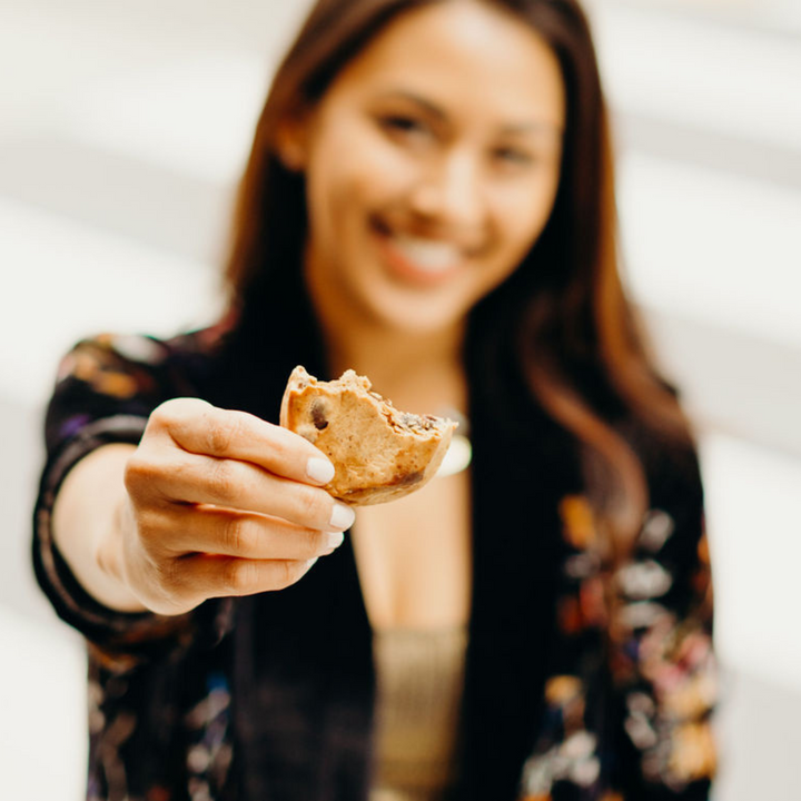 Woman smiling holding Rule Breaker Snacks blondie