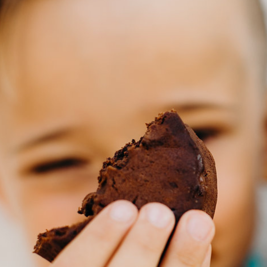 Boy holding Rule Breaker Snacks deliciously soft-baked allergen free vegan gluten free brownie